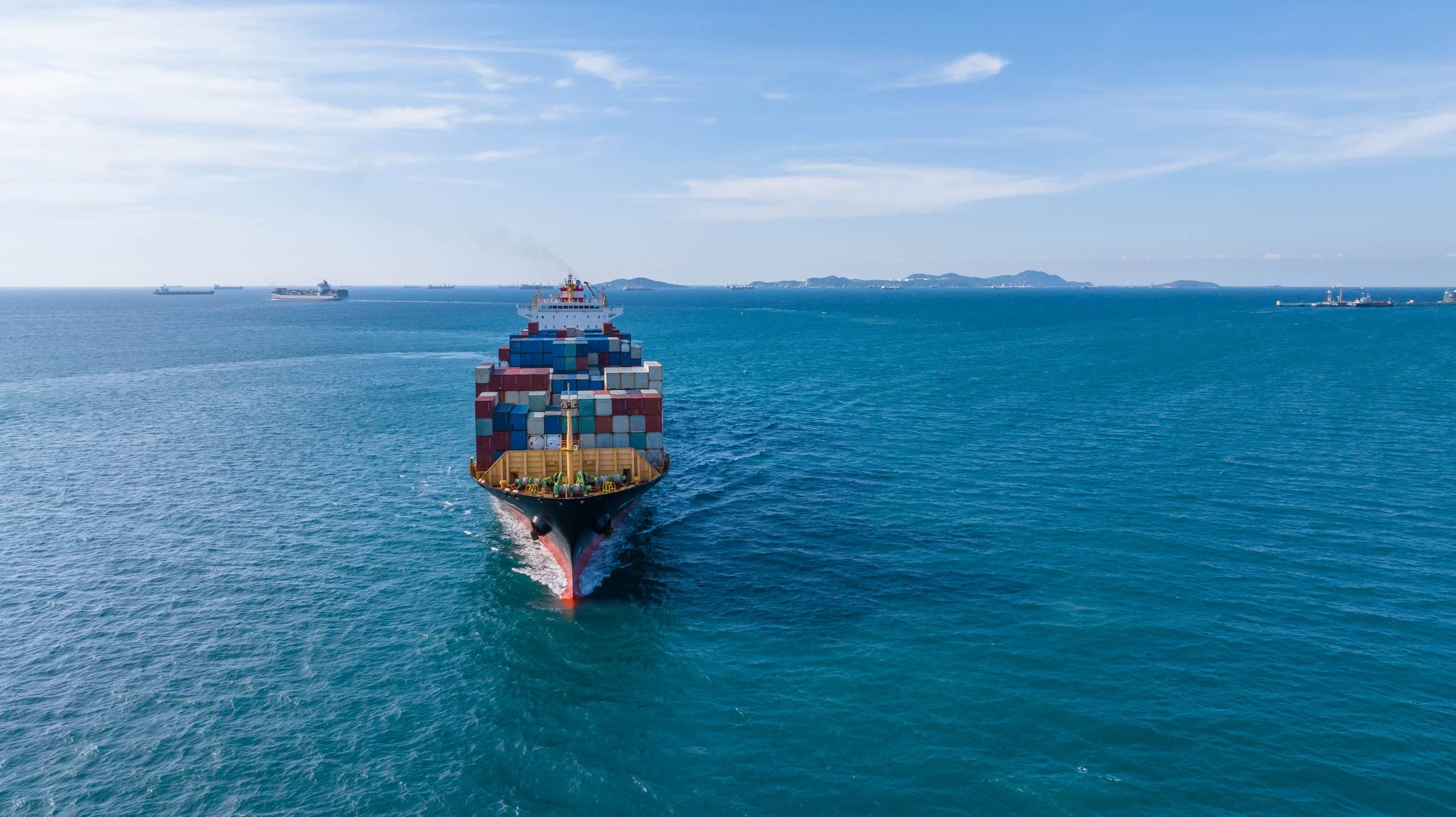 Container vessel under way with the coastline behind